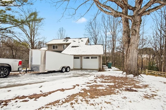 view of snow covered exterior featuring a garage