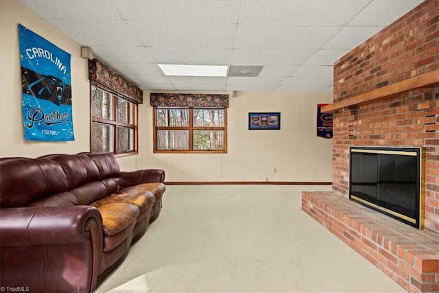 carpeted living room with a paneled ceiling and a fireplace