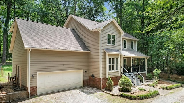 4008 Windspray Loop, Summerfield, NC 27358 - traditional home with gravel driveway, a shingled roof, a garage, and a porch