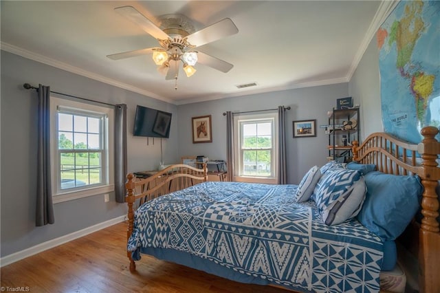 bedroom featuring hardwood / wood-style floors, ceiling fan, and crown molding