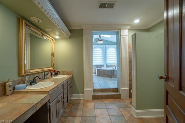 bathroom featuring tile patterned floors, ornate columns, crown molding, and vanity