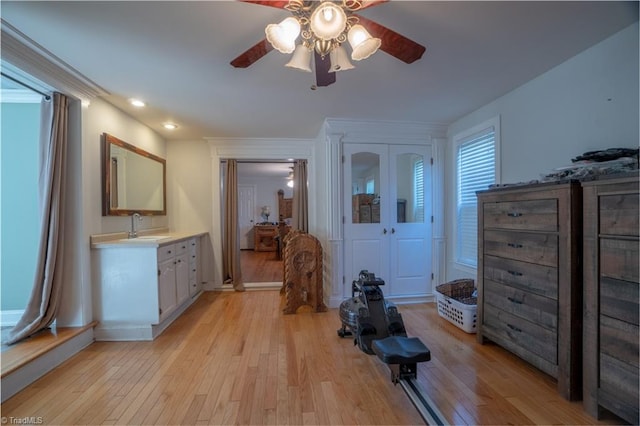 interior space with ceiling fan, sink, and light hardwood / wood-style flooring