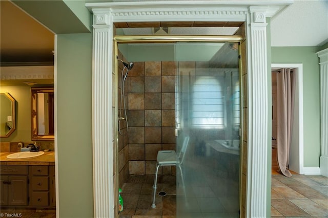 bathroom with vanity, ornamental molding, and tiled shower