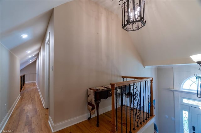 foyer featuring a chandelier, vaulted ceiling, and hardwood / wood-style flooring