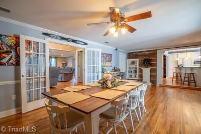 dining area with hardwood / wood-style flooring, ceiling fan, and crown molding