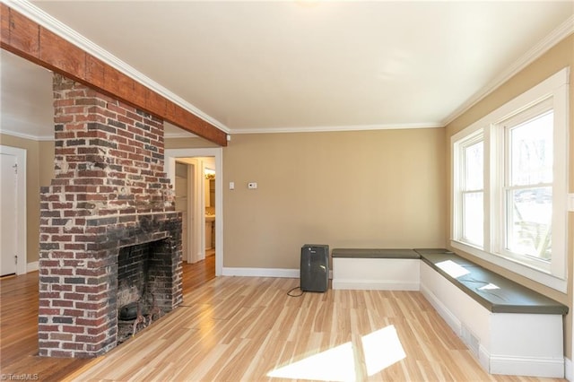 unfurnished living room featuring a fireplace, ornamental molding, and light hardwood / wood-style floors