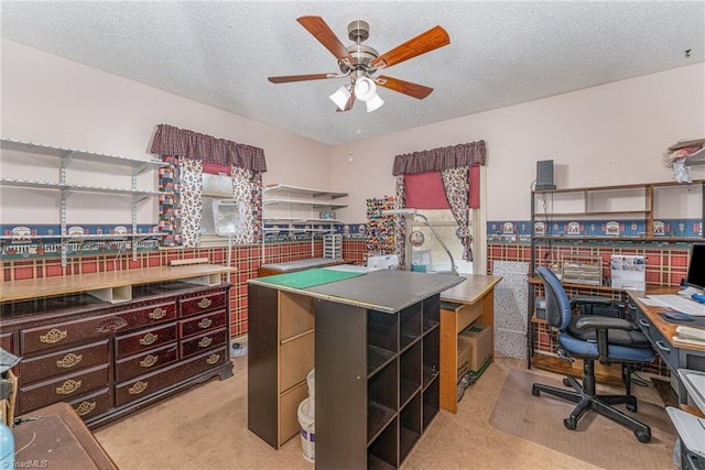 home office featuring a textured ceiling, a wainscoted wall, carpet floors, and ceiling fan