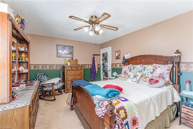 bedroom with light carpet, a textured ceiling, and ceiling fan