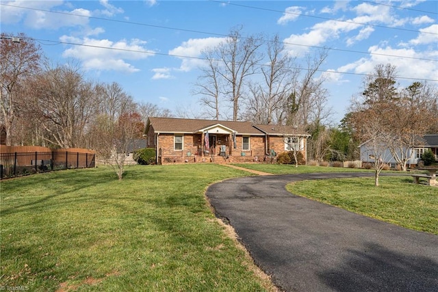 ranch-style house featuring a front yard and fence