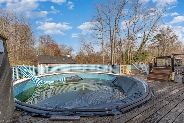 view of swimming pool with a wooden deck, a fenced in pool, and a jacuzzi