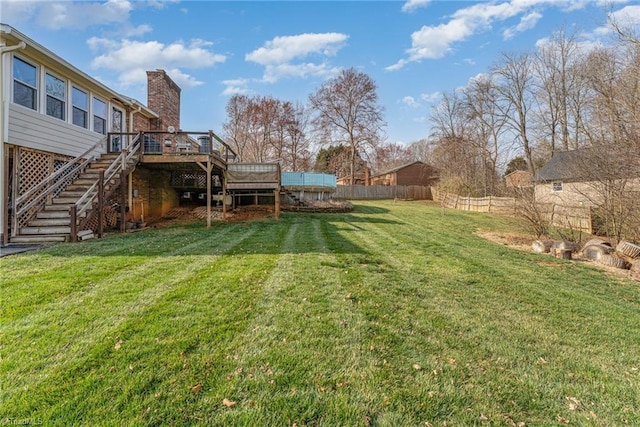 view of yard with stairway, a wooden deck, and fence