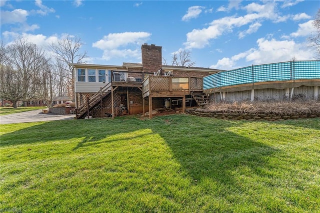 back of property featuring a yard, a chimney, a deck, and stairs