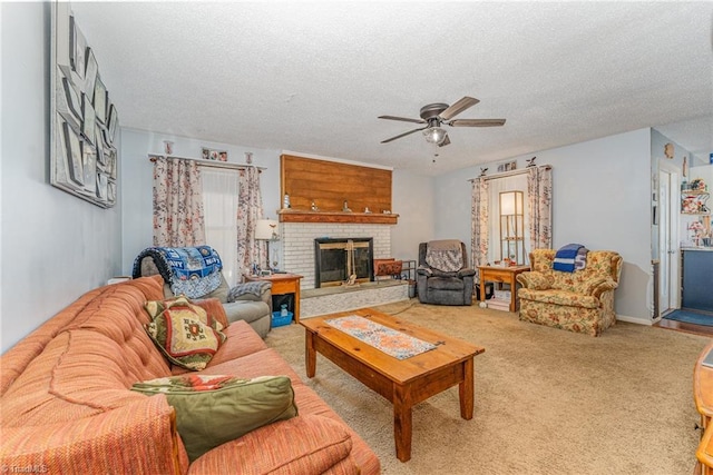 living room featuring carpet flooring, a textured ceiling, a fireplace, and a ceiling fan