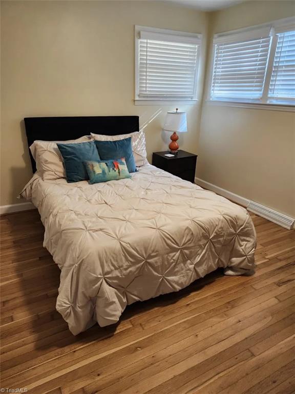bedroom featuring baseboards and hardwood / wood-style floors