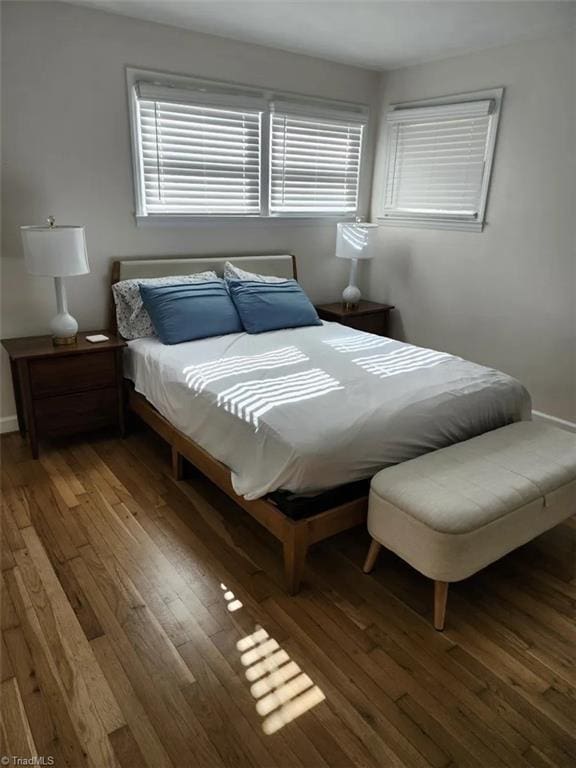 bedroom with baseboards and wood-type flooring