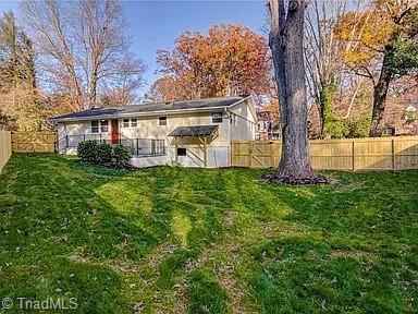 back of house featuring a fenced backyard and a yard
