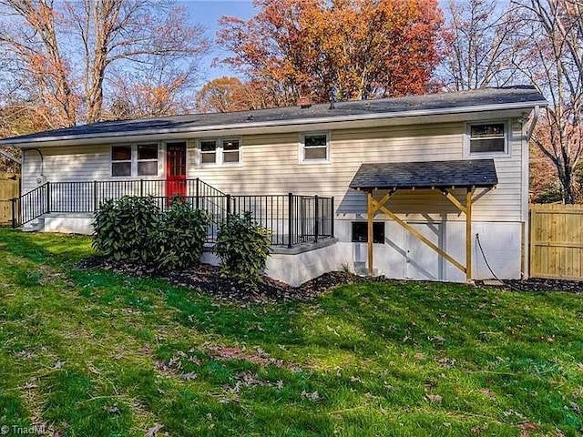 back of property with fence and a lawn