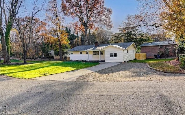 single story home with a front lawn, fence, driveway, and a chimney