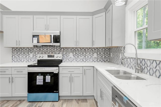 317 Styers Rd, Winston-Salem, NC 27105 - kitchen with light stone counters, a sink, light wood finished floors, and appliances with stainless steel finishes