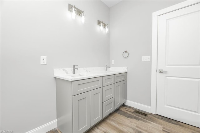 317 Styers Rd, Winston-Salem, NC 27105 - bathroom with a sink, double vanity, baseboards, wood finished floors, and visible vents