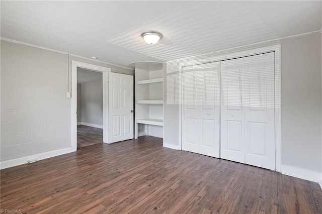 unfurnished bedroom with dark wood-type flooring and a closet