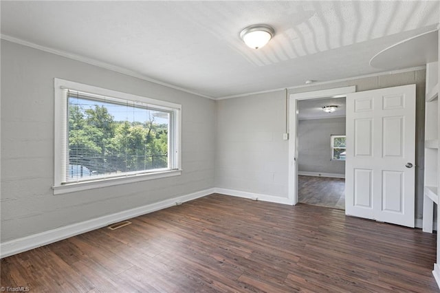 empty room featuring crown molding and dark hardwood / wood-style flooring