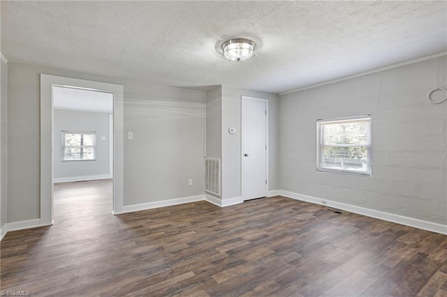 empty room with dark hardwood / wood-style floors and a textured ceiling