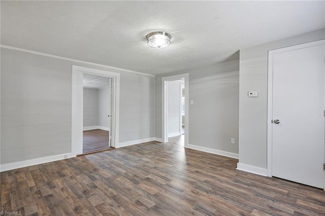 empty room with dark hardwood / wood-style floors and a textured ceiling