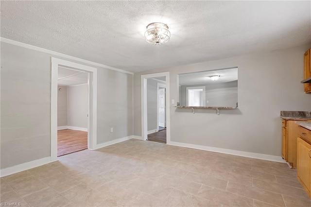 interior space with ornamental molding and a textured ceiling