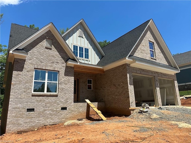 view of front of home featuring board and batten siding, brick siding, a garage, crawl space, and roof with shingles