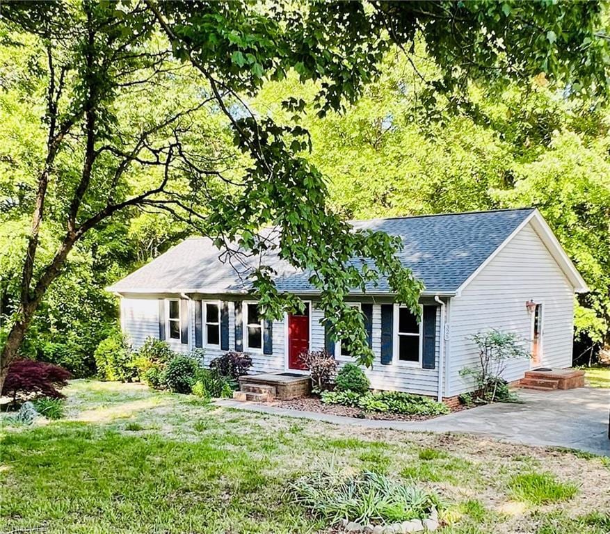 ranch-style home featuring a front yard and roof with shingles