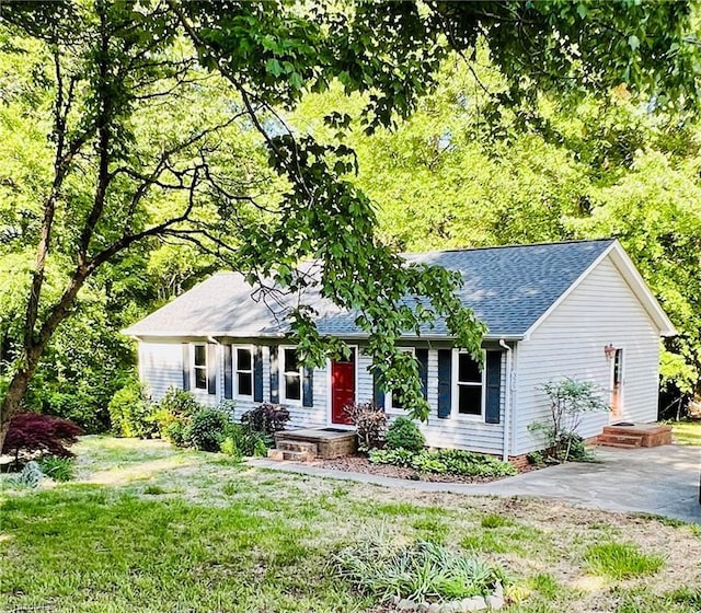 ranch-style home featuring a front yard and roof with shingles