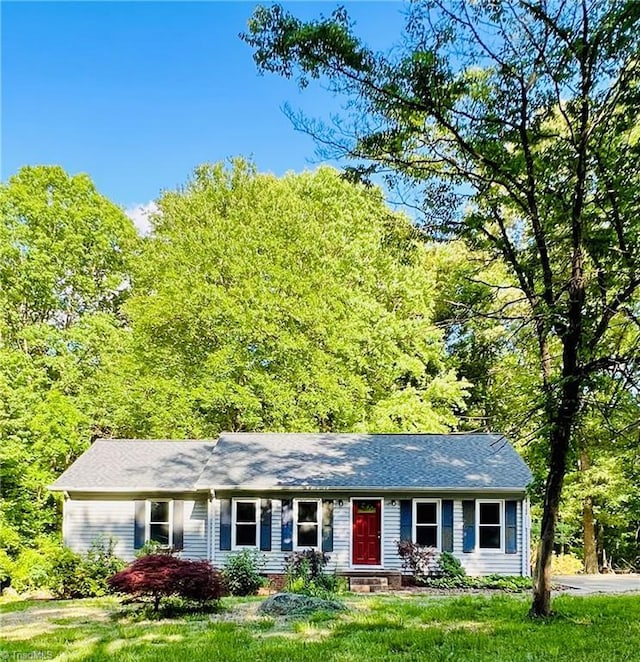 single story home with a view of trees and a front lawn