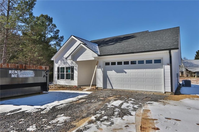 view of front of home with central AC and a garage