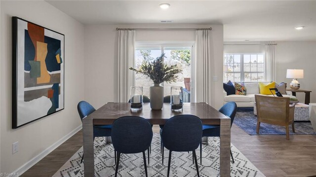 dining room with baseboards, wood finished floors, and recessed lighting