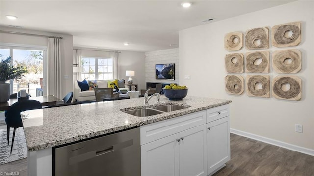 kitchen featuring stainless steel dishwasher, a sink, a kitchen island with sink, open floor plan, and dark wood-style flooring