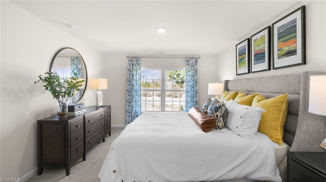 bedroom with light colored carpet and baseboards