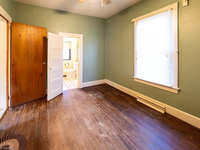 unfurnished bedroom with ensuite bathroom, multiple windows, and dark hardwood / wood-style flooring