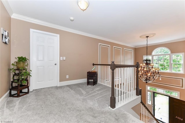 carpeted entryway featuring a chandelier, crown molding, and baseboards