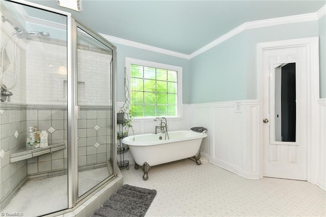 bathroom featuring a shower stall, a freestanding bath, ornamental molding, and a wainscoted wall
