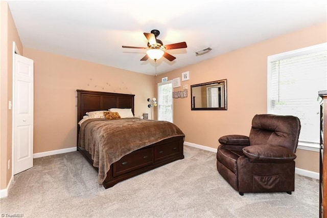 bedroom with multiple windows, light colored carpet, and baseboards
