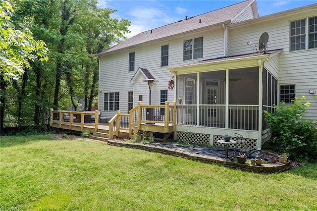 back of property featuring a sunroom, a lawn, and a wooden deck