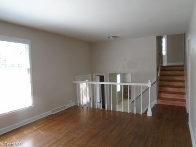 unfurnished room with dark wood-type flooring