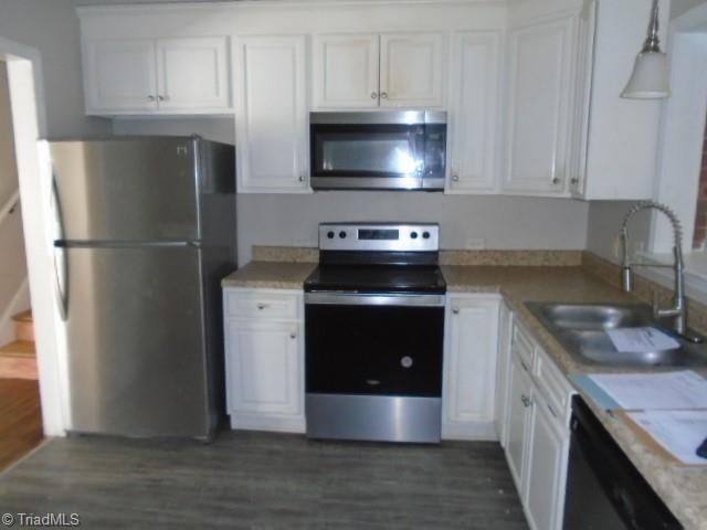 kitchen with stainless steel appliances, white cabinets, dark wood-type flooring, and sink