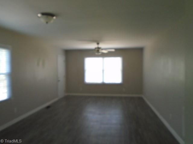 unfurnished room featuring a notable chandelier and dark hardwood / wood-style floors