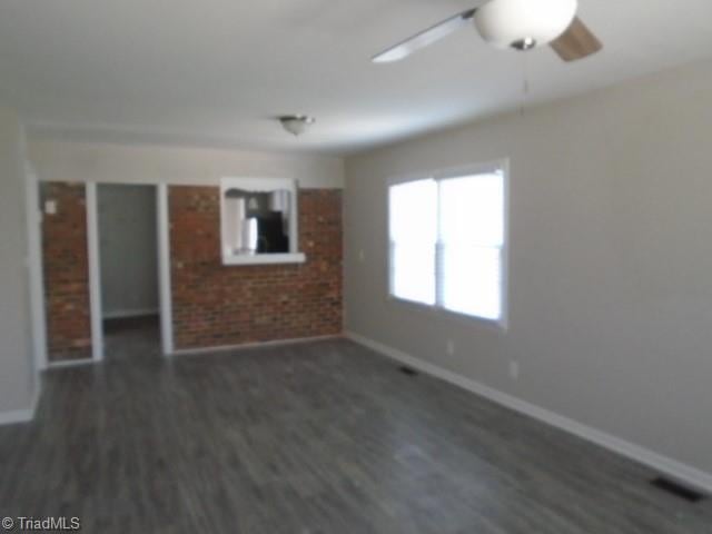 empty room featuring dark hardwood / wood-style flooring and ceiling fan