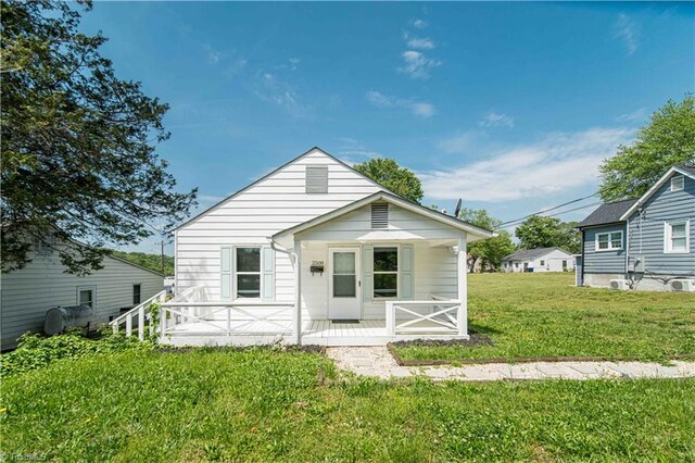 rear view of property with a lawn and a porch