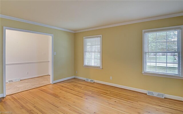 empty room featuring crown molding and light wood-type flooring