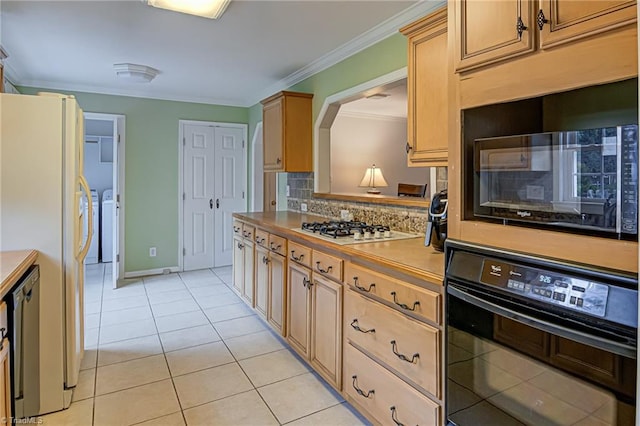 kitchen featuring independent washer and dryer, ornamental molding, light tile patterned floors, black appliances, and decorative backsplash