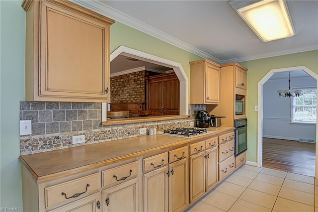 kitchen featuring ornamental molding, a notable chandelier, appliances with stainless steel finishes, and decorative backsplash